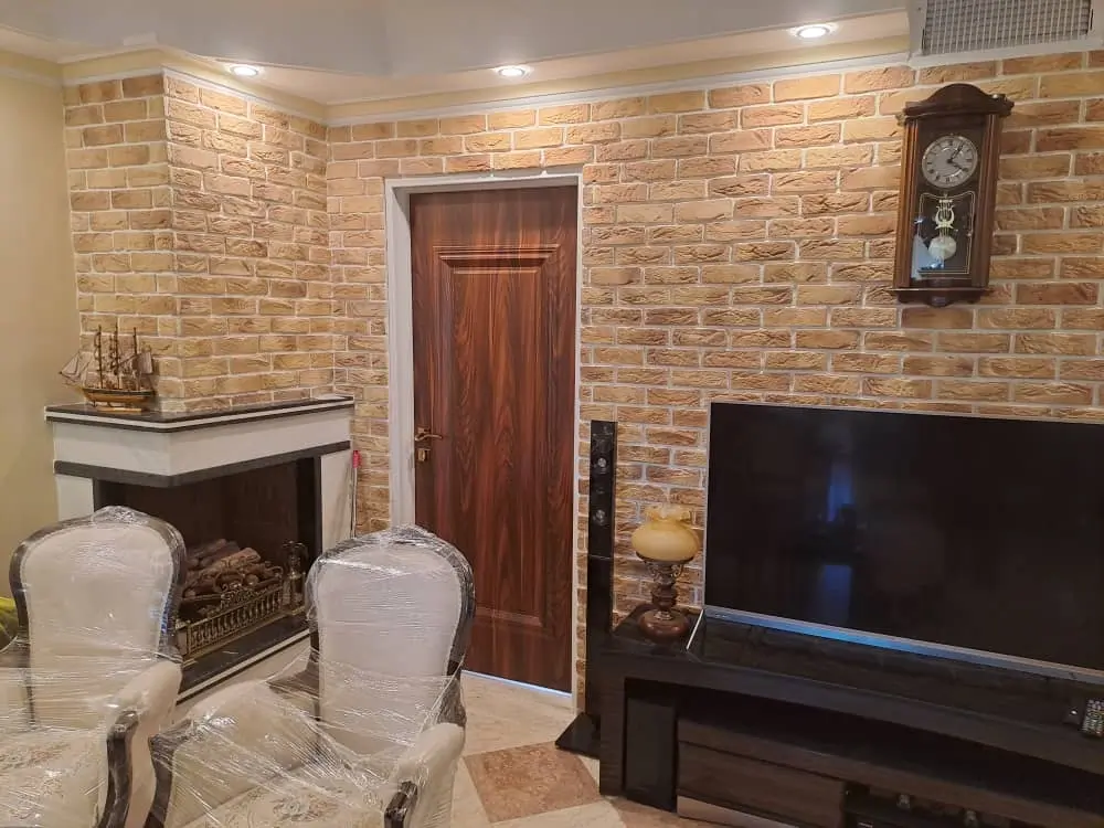 brown-decorative-brick-around-tv-corner دیوار اتاق نشیمن با آجر سفید و تلویزیون